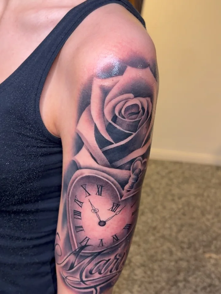 Rose und Taschenuhr auf dem Oberarm